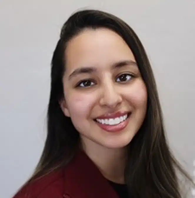 Young woman smiling at camera, professional headshot against neutral background.