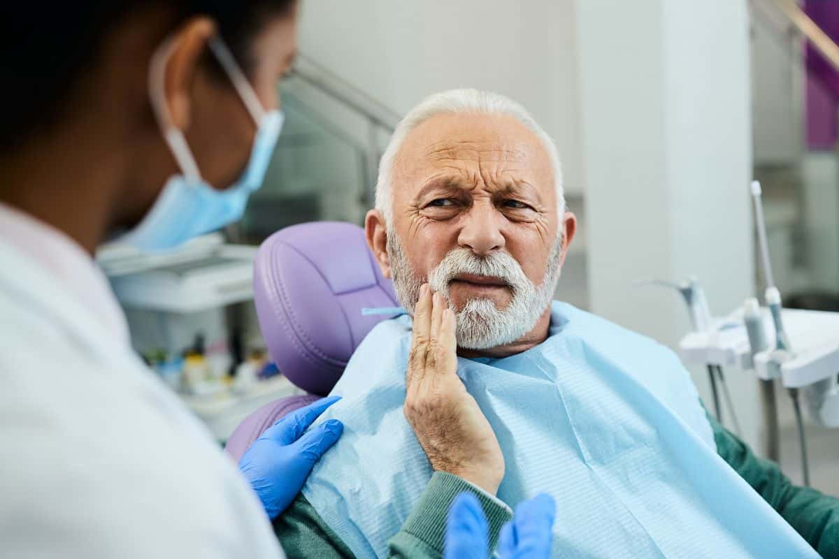 A patient experiencing mild discomfort after dental implant surgery consults with a dentist about recovery, healing, and the best foods to eat after dental implants. Proper nutrition and aftercare play an important role in successful implant healing.